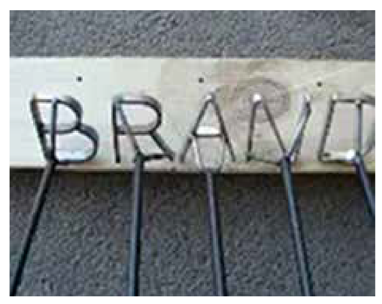 Set of letter branding irons on a board